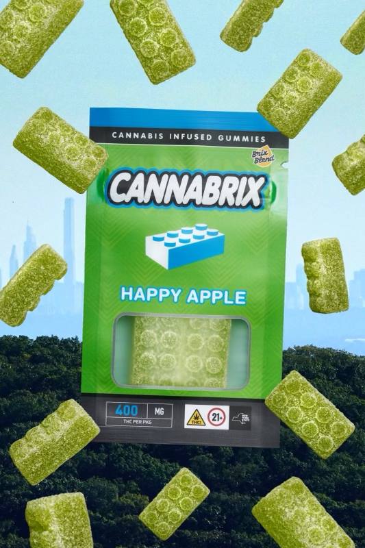 Green cannabis-infused gummies, Cannabrix Happy Apple flavor, displayed with New York City skyline in the background.