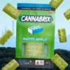 Green cannabis-infused gummies, Cannabrix Happy Apple flavor, displayed with New York City skyline in the background.