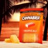 Cannabis-infused gummies by Cannabrix, Tropicali flavor, on sandy beach at sunset with palm trees.