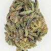 Close-up of a cannabis bud showcasing its vibrant green and orange hues, rich texture, and frosty trichomes.