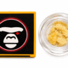 Close-up of a cannabis concentrate jar beside branded packaging featuring a stylized gorilla logo.
